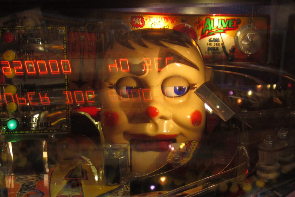 Clown reflected in pinball machine